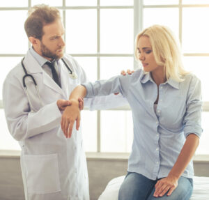 A doctor helping a patient with arm pain.