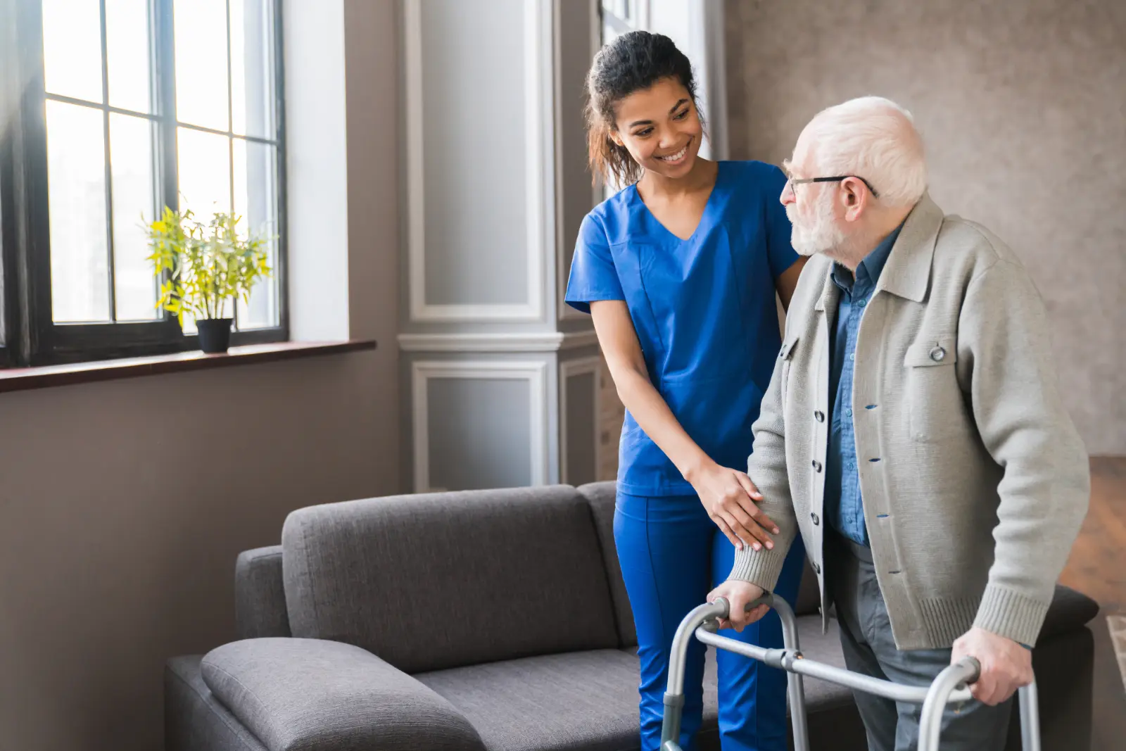 Surgery Options for Seniors. young nurse helping old elderly disable man grandfather to walk using walker